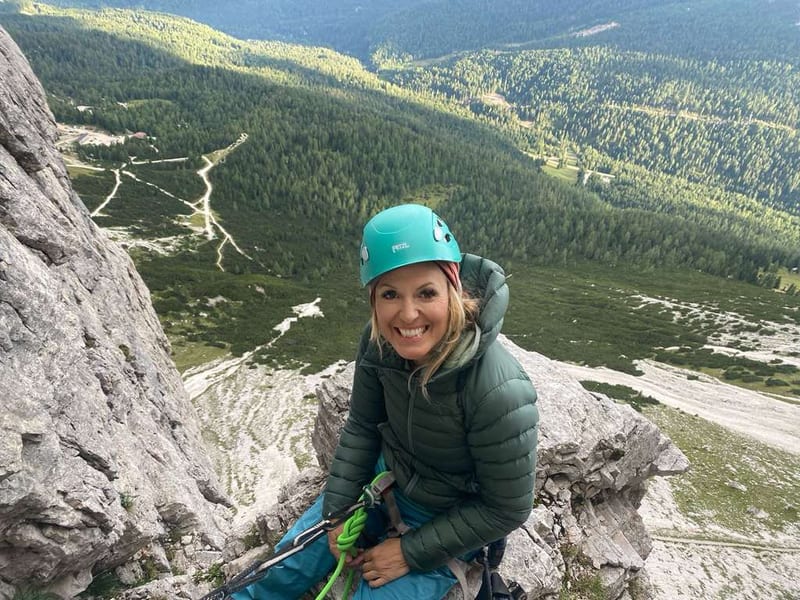 Kat Heldman smiling on a mountain ledge