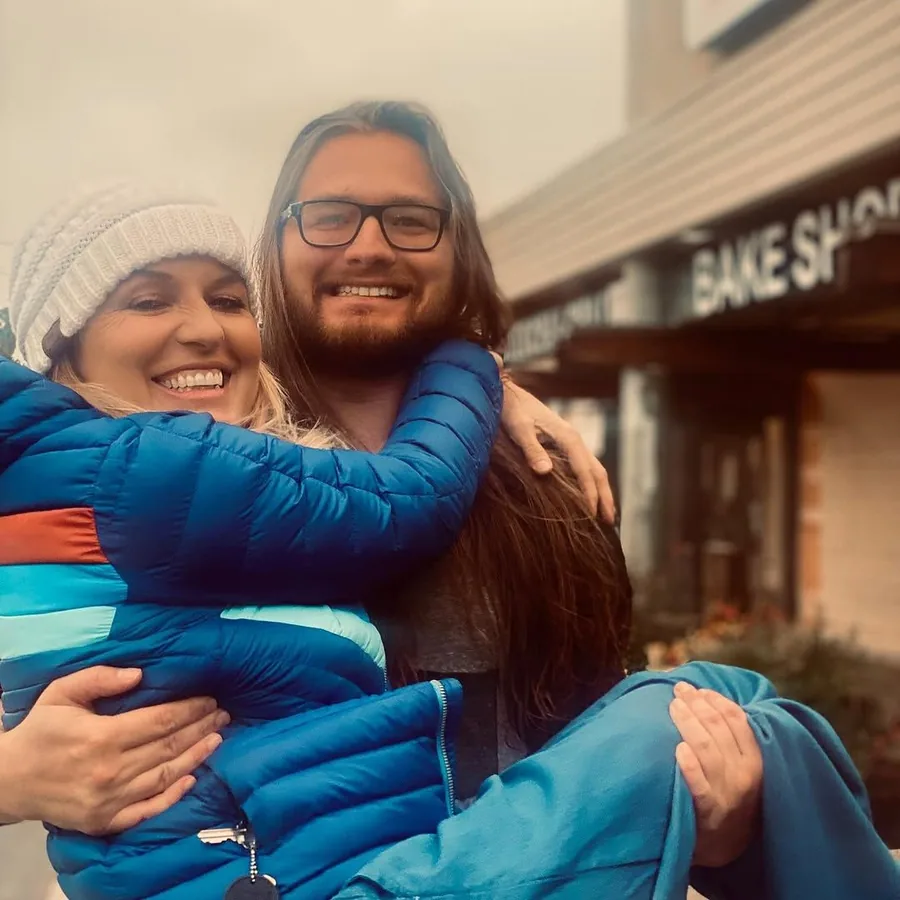 Kat being lifted in a hug outside a bake shop